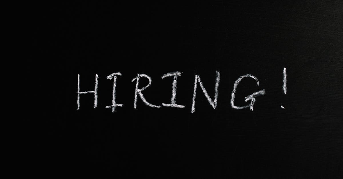 Close-up of the word 'Hiring!' written in white chalk on a blackboard, ideal for recruitment themes.